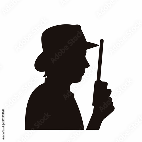 Silhouette of a person wearing a hat holding a walkie talkie