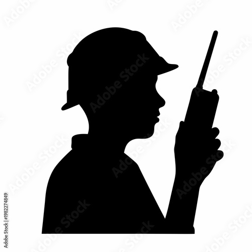 Silhouette of construction worker wearing hard hat and using a radio transmitter