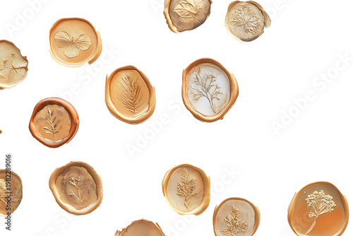 A collection of irregular gold wax seals with botanical imprints scattered on a white surface 
