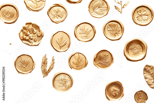 A collection of irregular gold wax seals with botanical imprints scattered on a white surface 