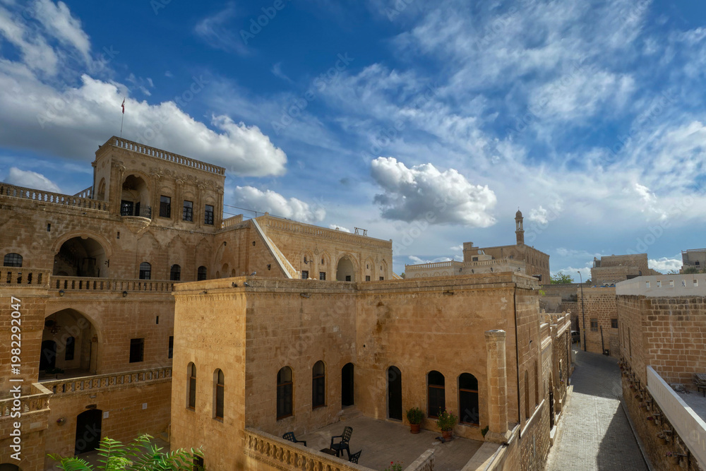 Fototapeta premium Historic stone architecture in Midyat, Mardin, showcasing traditional Middle Eastern and Anatolian design under blue sky