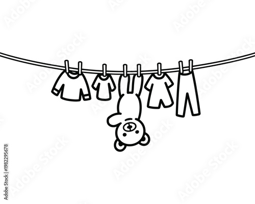Teddy bear hangs on a clothesline rope.