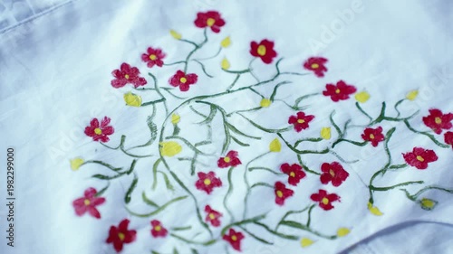 Traditional Bangladeshi hand-painted fabric on a child girl’s white gown with colorful folk art patterns, vibrant textile details, cultural fashion design, and artistic dress decoration.