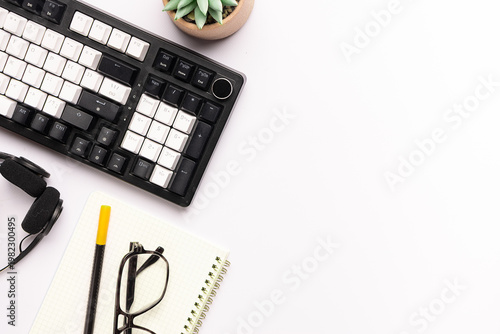 Office style composition with keyboard, notepad, cup of herbal tea and succulent flower on white background top view, long banner format, copy space for your design.