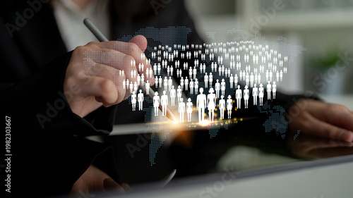 Fotografija Business professional using digital tablet for global communication and connection with people icons and world map representation in a modern office setting Quark