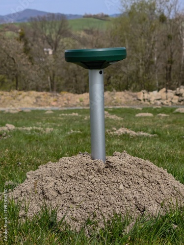 European Mole (Talpa europaea) – molehill with solar-powered repellent device in grassy habitat, common species in the Czech Republic