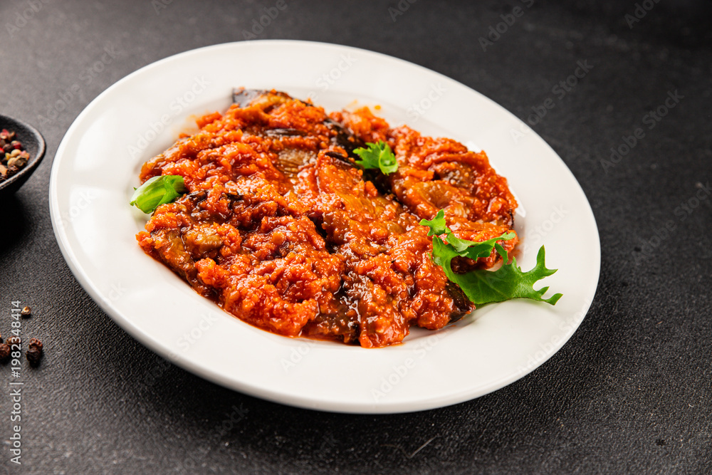 Fototapeta premium Eggplant vegetable sauce tomato, carrot, onion, chopped vegetables ajapsandali tasty snack fresh delicious gourmet food background on the table rustic food,top view copy space keto and paleo diet 