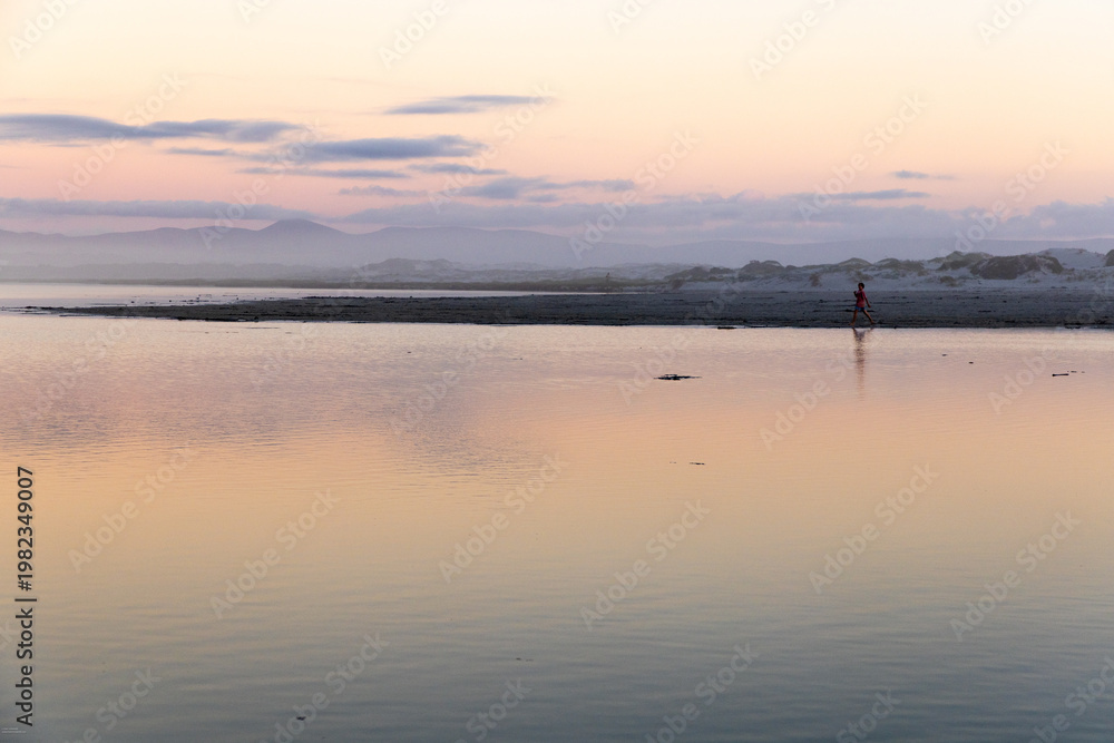 Fototapeta premium young boy playing at lagoon edge, Hermanus, South Africa