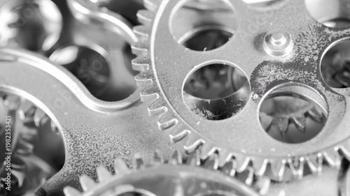 High-contrast macro footage of rotating silver gears. Perfect for topics on modern engineering, precision, and industrial innovation.