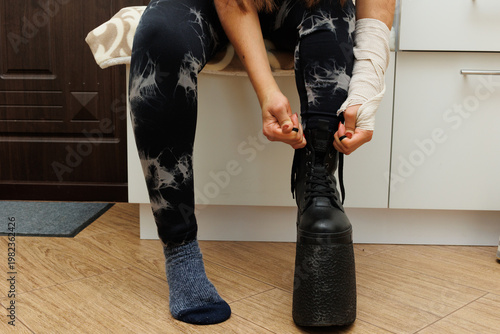 Woman tying her shoes at home