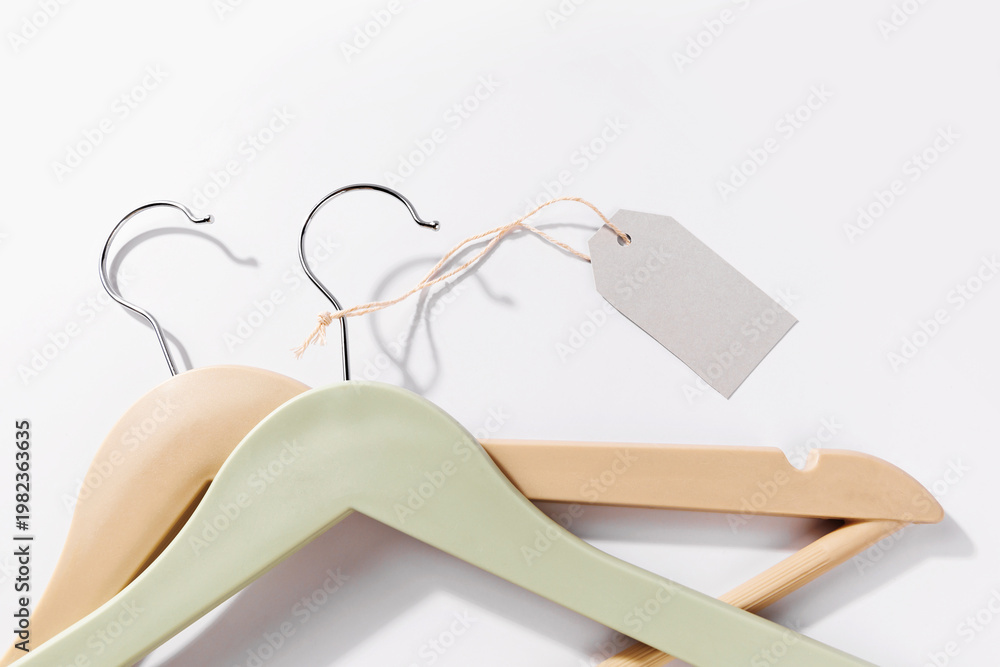 Ταπετσαρία clothes hangers with blank tag and copy space on light background fashion retail