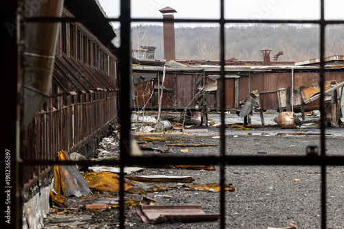 Abandoned Industrial Rooftop Complex Viewed Through Rusted Iron Grid Window