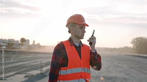 Professional builder talking with worker via radio set