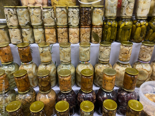 Foto Pickled mushrooms in glass jars at market dangerous homemade canned food