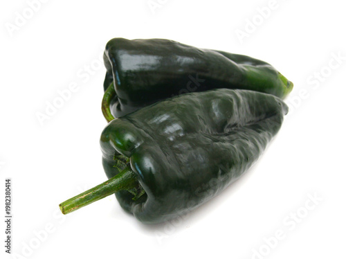 Stack dark green poblano peppers isolated on white