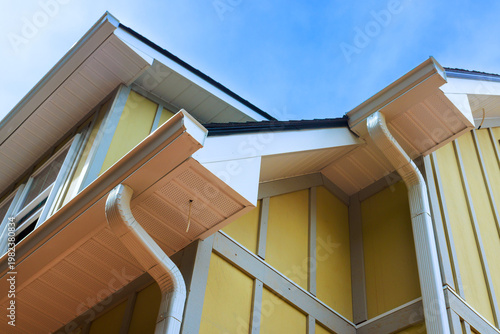 Fotografie Roof details gutters on yellow house under construction site.