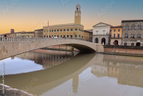 The Ponte di Mezzo Historic Old Stone Arch Bridge over Arno River Side View.  Famous Renaissance Tourist Landmark, Winter Sunset Sky, Pisa Tuscany Italy