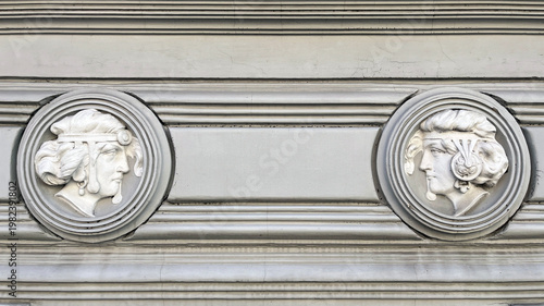 Fotografija Two classical sculpted heads in circular medallion reliefs embedded in a histori