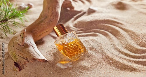 Beautiful golden perfume in translucent glass bottle on beach.