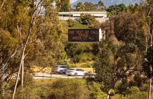 A digital traffic sign stating One Text or Call Could Wreck It All.  The image is from far away on the 15 freeway looking onto a freeway.  The image is in Escondido Ca