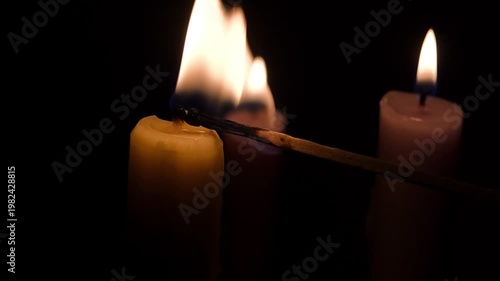 Lighting Candle with Match, Three Candles Close-Up on Black Background, Warm Flame, Dark Minimal Scene, Copy Space