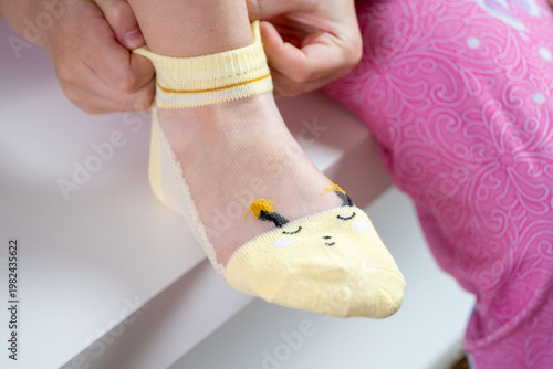 Quadro su tela child, Preschooler girl learning to dress independently, putting sock, Young kid