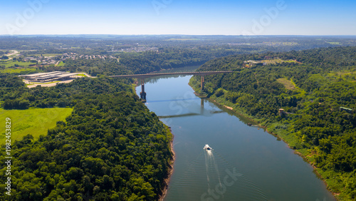 Aerial view of Tancredo Neves Bridge over Iguazu River with boat crossing border.