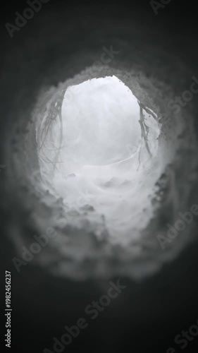 Mysterious subterranean tunnel filled with a wispy haze. Wind blowing and swirling through an eerie fog filled cave. Ominous cavern opening to spooky old burrow, underground sewer, or dugout.