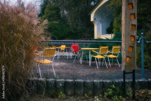 A red chair among the scattered yellow chairs in the park
