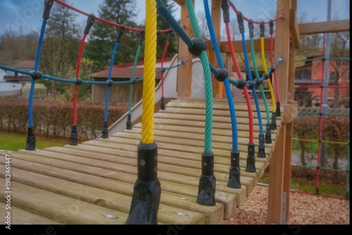 Children's toy bridge with colorful ropes in the park
