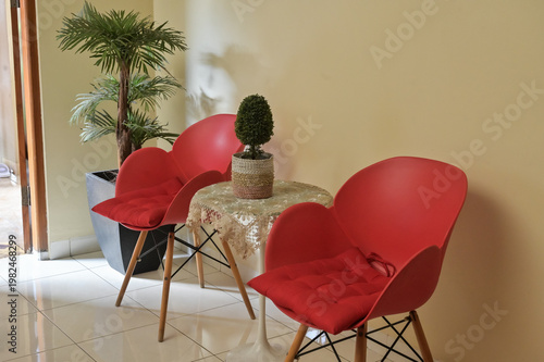 Pair of simple red chair for visitor with houseplant decoration