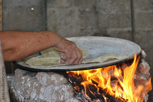 Hand Flipping Corn Tortillas on Hot Clay Comal