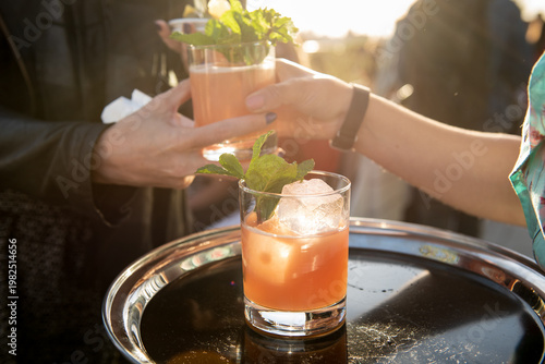 Pink Cocktails Being Passed at an Outdoor Party 
