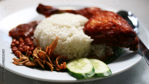 Nasi lemak ayam goreng. Coconut Rice with Fried Chicken. Malaysian dish consisting of fragrant rice cooked in coconut milk and pandan leaves, served with crispy fried chicken.
