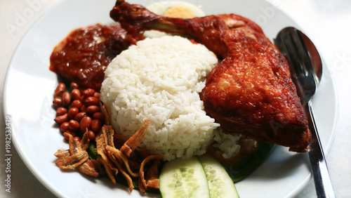 Nasi lemak ayam goreng. Coconut Rice with Fried Chicken. Malaysian dish consisting of fragrant rice cooked in coconut milk and pandan leaves, served with crispy fried chicken.