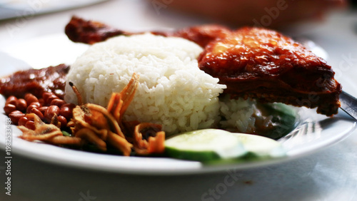 Nasi lemak ayam goreng. Coconut Rice with Fried Chicken. Malaysian dish consisting of fragrant rice cooked in coconut milk and pandan leaves, served with crispy fried chicken.