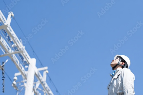 送電線を見上げる作業員