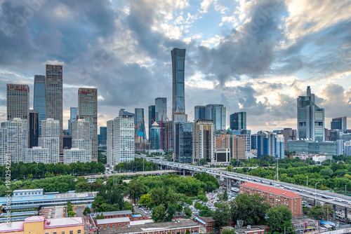Beijing CBD, modern skyscrapers, elevated highway traffic, surrounded by green trees, urban construction, city skyline
