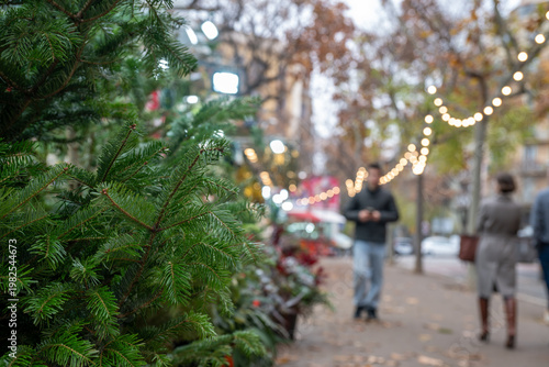 Christmas tree market in the city with shoppers during holiday season in December