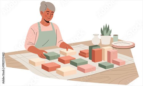 person arranging handmade soap bars in various shapes and colors on a table