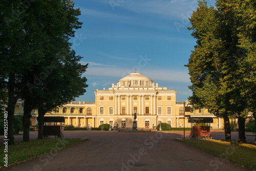 Summer Palace of Emperor Paul I in Pavlovsk and the the monument to Emperor Paul I from the Triple Linden Alley on a sunny day, Pavlovsk, St. Petersburg, Russia
