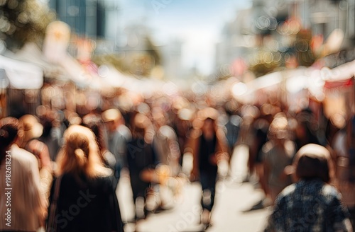 A blurred, sun-drenched street scene captures the bustling energy of a crowded outdoor market, filled with indistinct figures and colorful stalls.