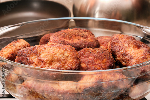 fluffy cutlets prepared at home in a glass bowl, close-up