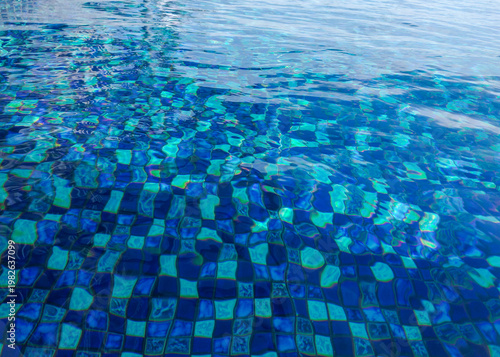 Crystal Clear Blue Swimming Pool Water with Ripples and Mosaic Tiles – Refreshing Summer Vacation and Wellness Background with Light Reflections

