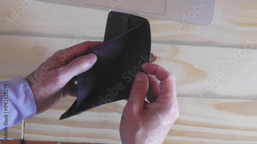 Broke man opening and closing empty wallet. Counting euro money at home