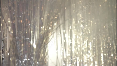 Woman in red dress standing behind blue tinsel with a melancholic expression
