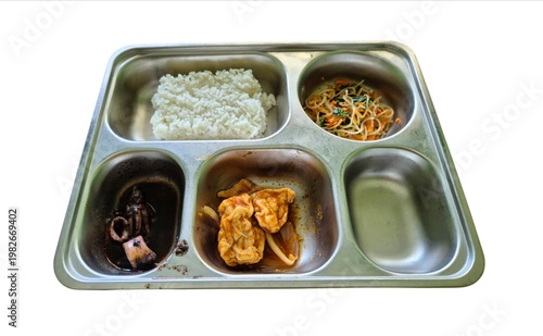 A stainless steel food tray containing rice, vermicelli, tofu, and squid, isolated on a white background. Government's free nutritious food program.