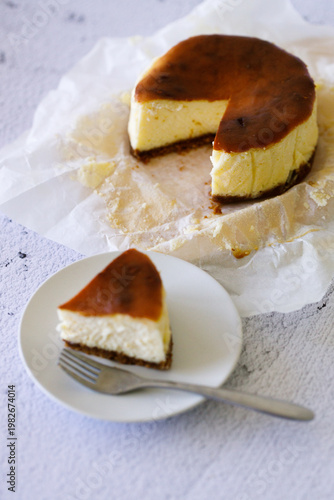 Cheesecake with baking paper on white marble table.
