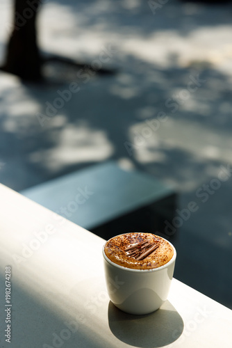 Cup of hot milk latte coffee on table by the window.