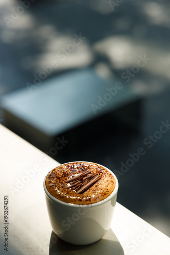 Cup of hot milk latte coffee on table by the window.